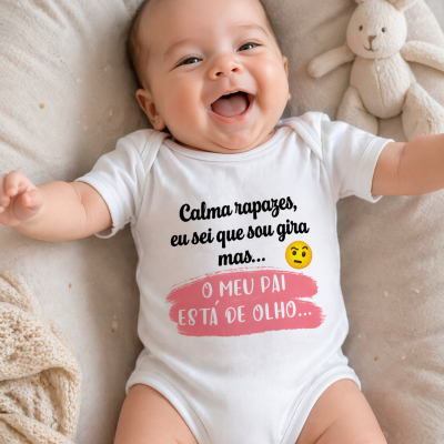 Bebé com body branco e texto estampado deitado em almofada bege ao lado de peluche coelho creme