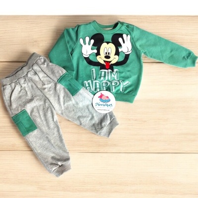 Conjunto de roupa infantil com camisola verde e calças cinzentas, estampa do Mickey e etiqueta da marca.