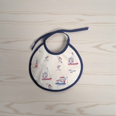 Babete branco com estampado azul e vermelho de motivos marinhos e ursinhos