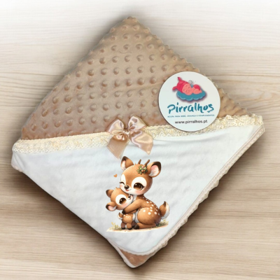 Manta de bebé bege e branca com ilustração de veados e etiqueta da marca Pirralhos