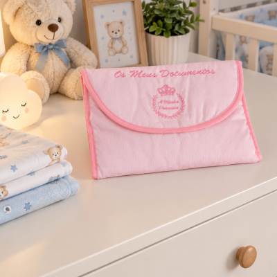 Bolsa rosa de tecido para documentos numa cómoda branca com decoração infantil de ursinho e plantas