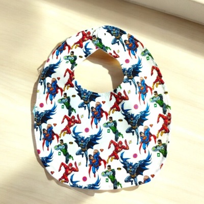 Babete de bebé com estampado de super-heróis em tecido branco