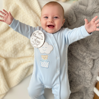Bebé sorridente com macacão azul claro e peluches ao fundo
