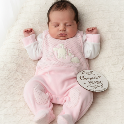 Bebé a dormir com fato rosa e branco e manta bege