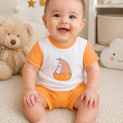 Bebé sorridente com roupa laranja e branca sentada em tapete bege com urso de peluche ao fundo