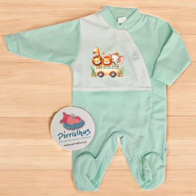 Macacão de bebé verde com estampado de animais em autocarro sobre superfície de madeira