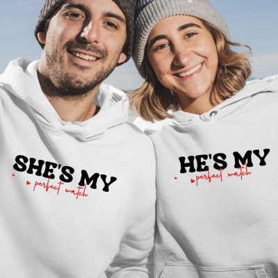 Casal com sweatshirts brancas e gorros de malha sorrindo ao ar livre
