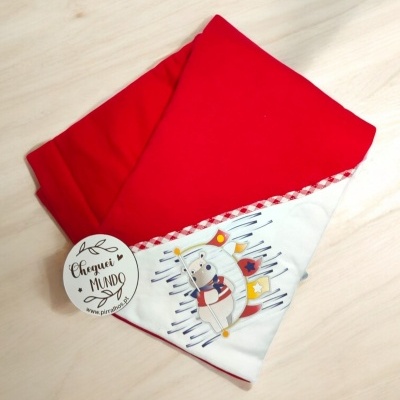 Manta infantil vermelha com padrão de animais e etiqueta redonda