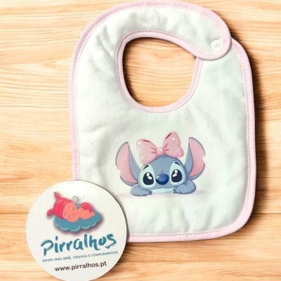 Babete de bebé branco com borda rosa e personagem azul com laço rosa