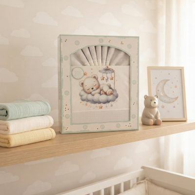 Prateleira com tecidos pastel, caixa decorativa com ursinho em nuvem e moldura da lua, em quarto infantil