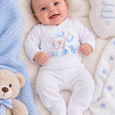 Bebé sorridente com roupa branca e manta azul