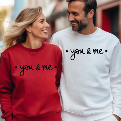 Homem e mulher sorrindo usando sweatshirts branco e vermelho com texto • you & me •