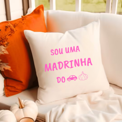 Almofada branca com texto cor-de-rosa num sofá com almofadas e decoração outonal