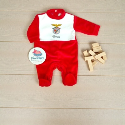 Macacão de bebé vermelho e branco com bordado Tomás sobre chão de madeira com blocos de madeira e etiqueta