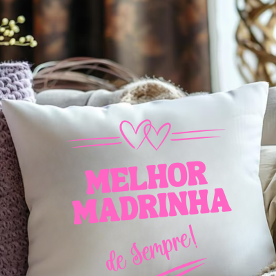 Almofada branca com texto rosa Melhor Madrinha de Sempre e dois corações em sofá com mantas