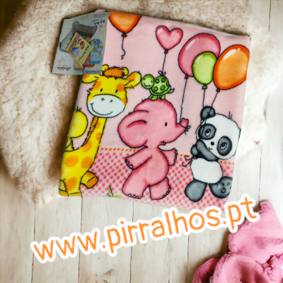 Cobertor infantil rosa com animais e balões coloridos sobre tapete e chão de madeira