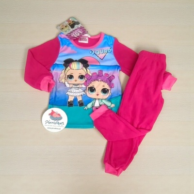 Conjunto de pijama infantil com estampa colorida e calças cor-de-rosa sobre superfície de madeira clara.