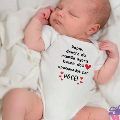 Body de bebé branco com texto impresso em português e bebé a dormir