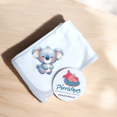 Manta branca com ilustração de coala e cartão redondo com logótipo Pirralhos