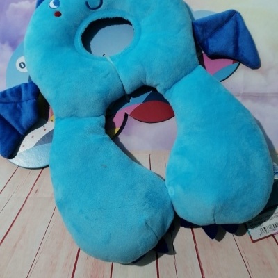 almofada de viagem azul em forma de personagem com olhos e sorriso