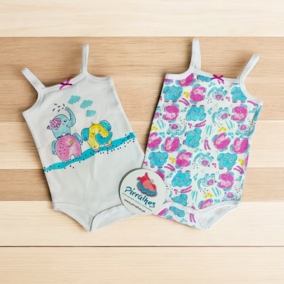 Dois bodies de bebé com temas de dinossauros em fundo de madeira clara