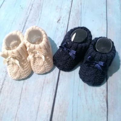 Dois pares de sapatinhos de bebé em malha bege e azul escuro com laços