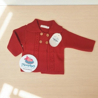 Casaco vermelho de malha para bebé com botões de madeira e etiquetas visíveis