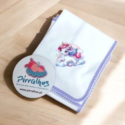 Fralda branca com unicórnio colorido e borda lilás, cartão da marca Pirralhos