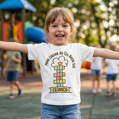 Criança sorridente com camisola branca estampada em parque de diversão