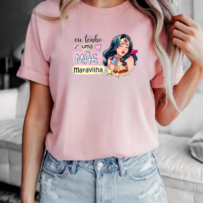 T-shirt rosa com estampado colorido e frase em português.