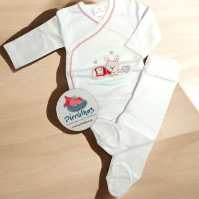 Conjunto de roupa de bebé branco com bordado de coelho e calças com pés em madeira clara