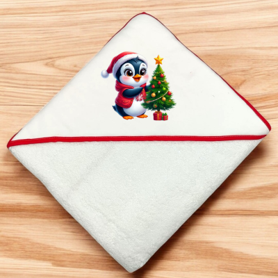 Toalha branca com borda vermelha e desenho de pinguim natalício junto a árvore de Natal