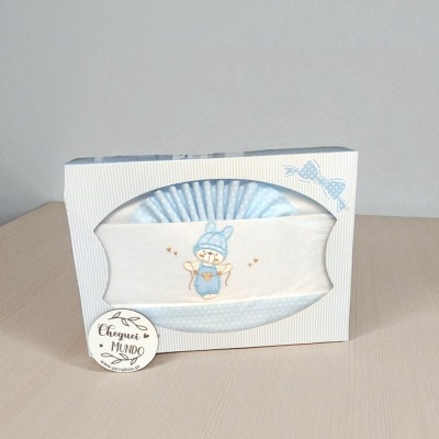 Conjunto de bebé azul e branco com bordado de ursos em caixa branca com riscas azuis