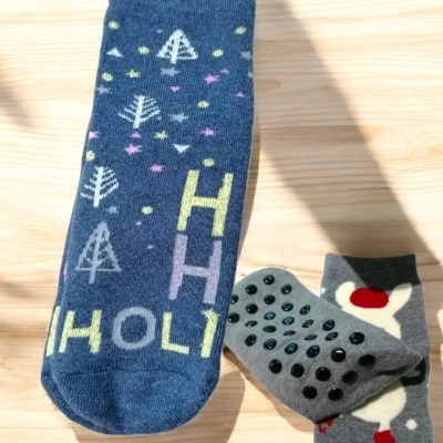 Meias antiderrapantes com padrões coloridos sobre fundo de madeira clara