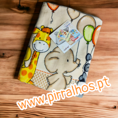 Manta infantil com desenhos de animais e balões sobre piso de madeira