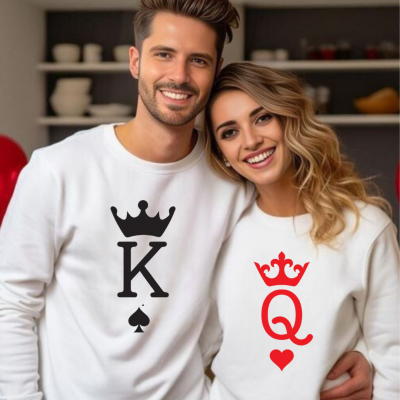 Casal com sweatshirts brancas, uma com 'K' preta e outra com 'Q' vermelha, em ambiente interior.