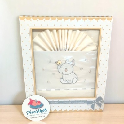 Conjunto de fraldas de pano com bordado de coelho e passarinho numa caixa decorada com padrões dourados