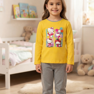 Criança com camisola amarela da Hello Kitty e calças cinzentas em quarto infantil