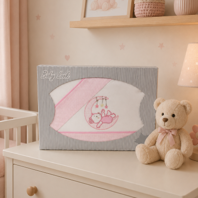 Conjunto de bebé em caixa com fraldas e toalha rosa e branca