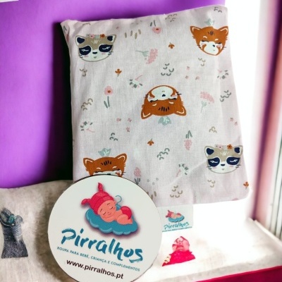 tecido com estampado de animais e placa com logotipo e texto