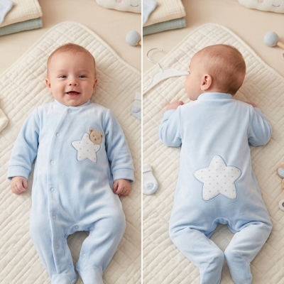 Bebé com pijama azul claro com estrela e urso em manta creme