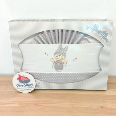 Caixa branca com roupa de bebé cinzenta com padrão de bolinhas e coelho bordado