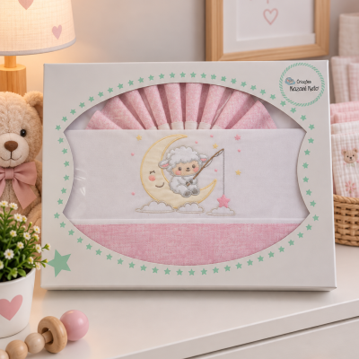Conjunto de roupa de cama rosa para bebé com bordado de ovelha na lua numa caixa branca com estrelas verdes