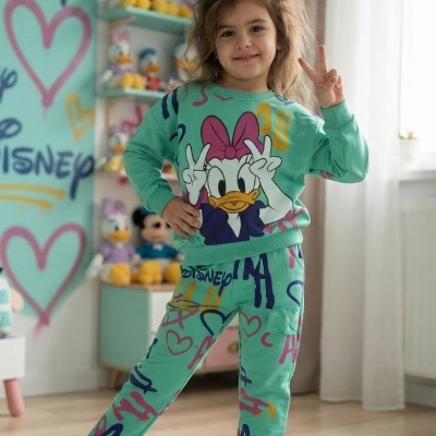 Criança com pijama verde da Margarida em divisão com decoração Disney