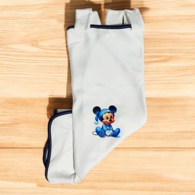 Luvas brancas com estampa do Mickey Mouse em roupa azul sobre fundo de madeira clara