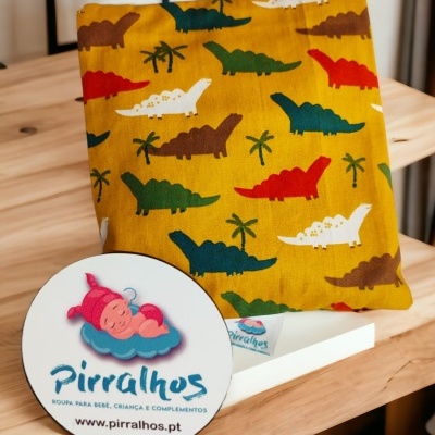 Tecido com padrão de dinossauros e logotipo da marca Pirralhos em placa redonda