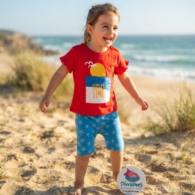 Criança com roupa colorida na praia, mar ao fundo