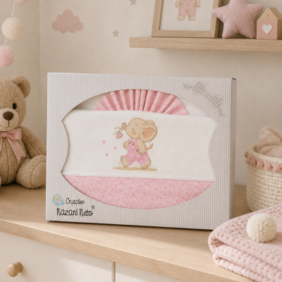 Conjunto de roupa de bebé rosa e branco com elefante, em caixa branca sobre móvel de madeira