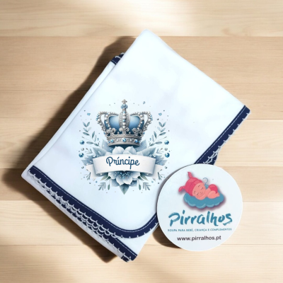 Fralda branca com coroa azul e palavra Príncipe, etiqueta Pirralhos ao lado