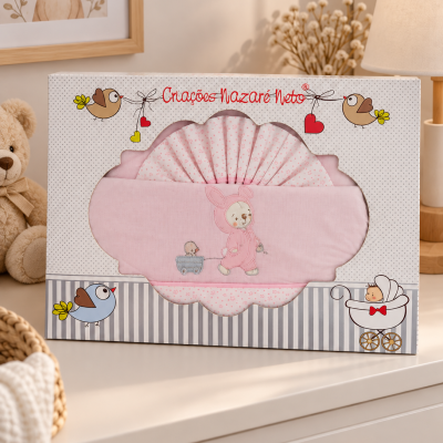 Conjunto rosa para bebé com padrão de pequenas flores em embalagem decorada com pássaros e texto Criações Nazaré Neto